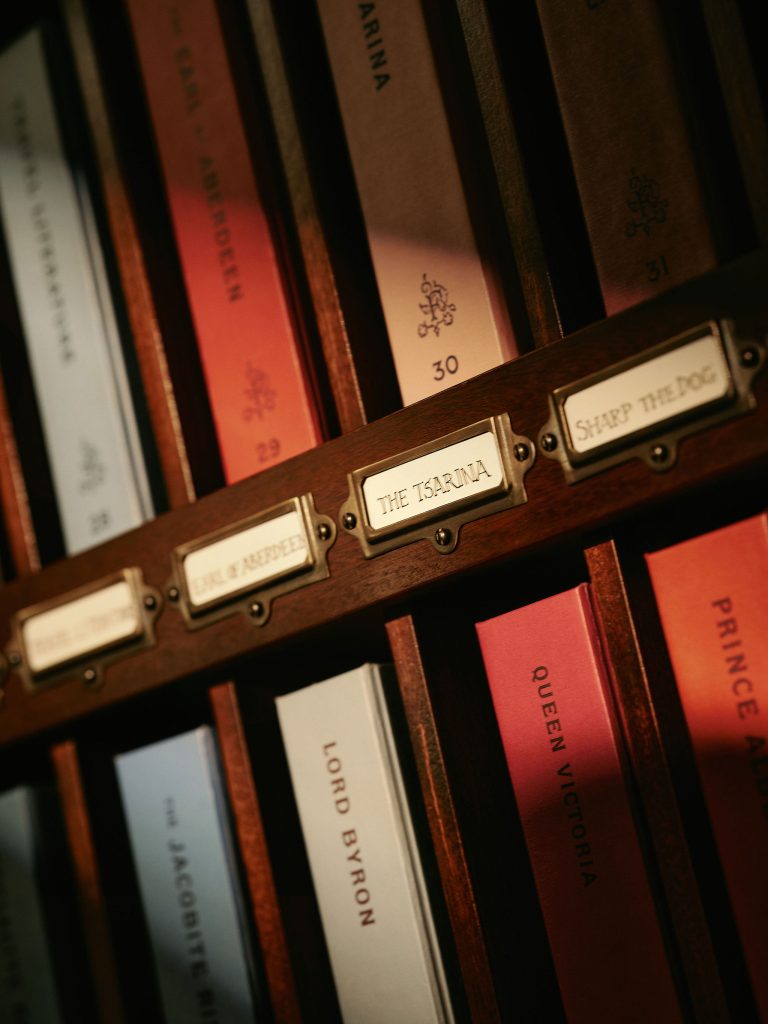 Varying coloured books holding room keys sat in pigeon holed shelving.