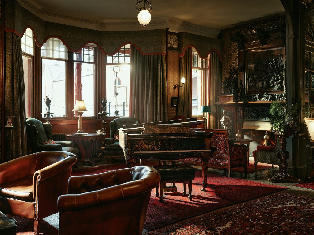 A view of the hotel lobby with the Mark Bradford Steinway piano in the centre and the Robert Burns fireplace to the right
