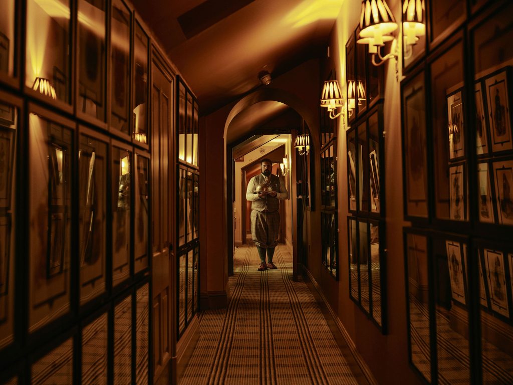 A porter delivering something to a guest walking down the corridor