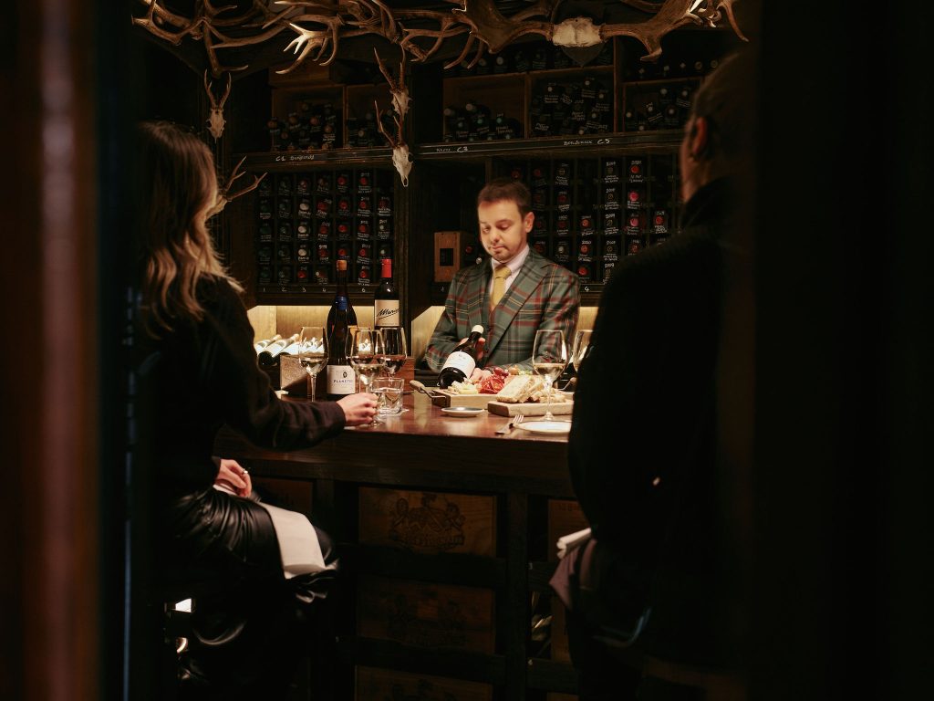 Staff member in the wine cellar hosting a wine tasting