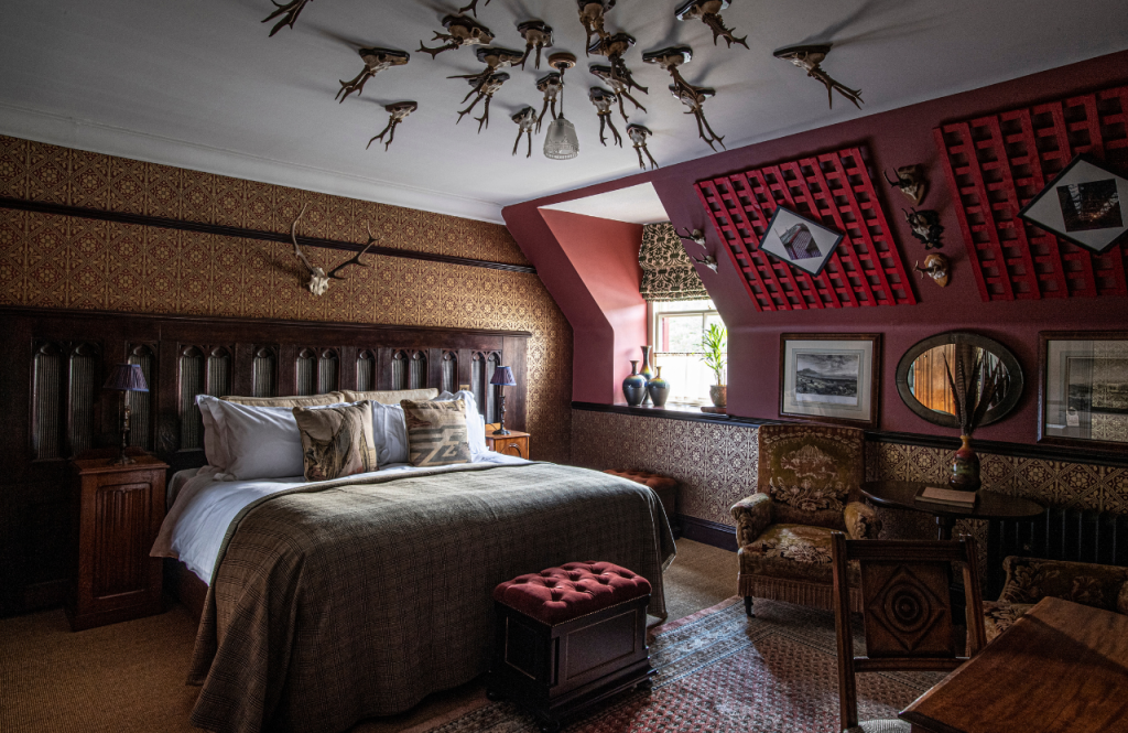The bed with stag horns overhead in the Architecture and Design room