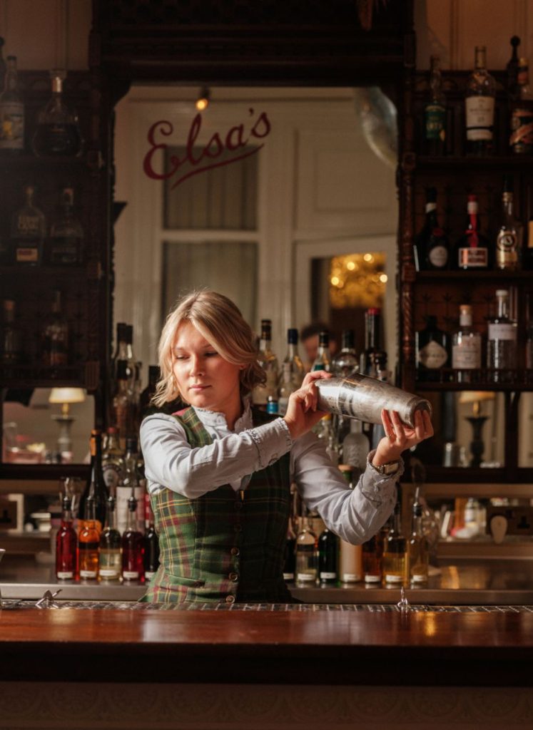 A waitress shaking up a cocktail in Elsa's Cocktail Bar