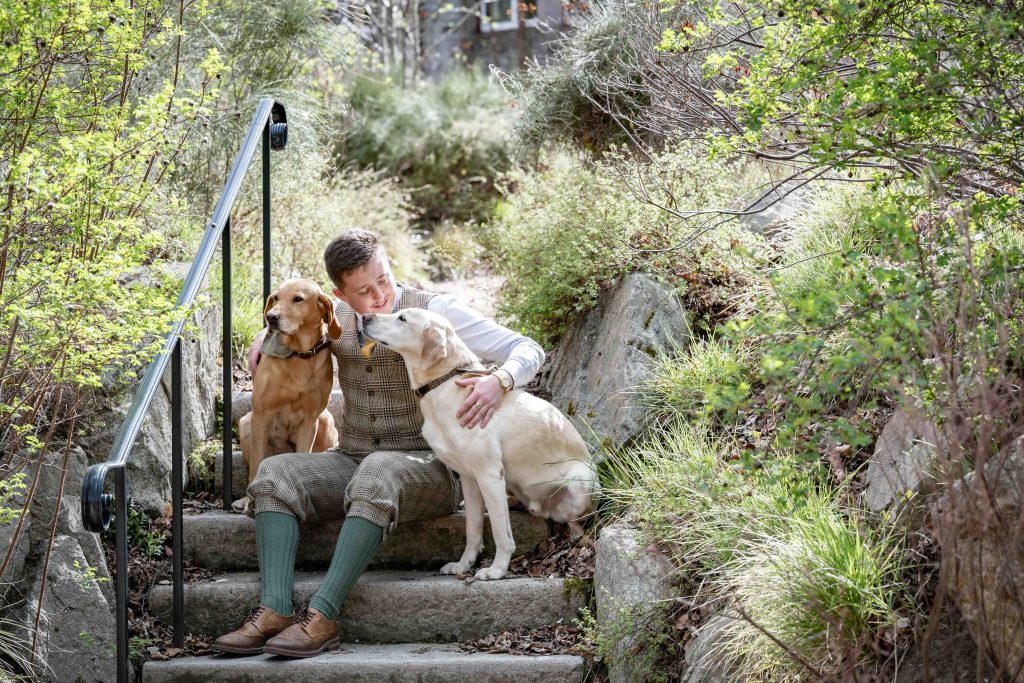 Hotel porter in the garden with his two dogs