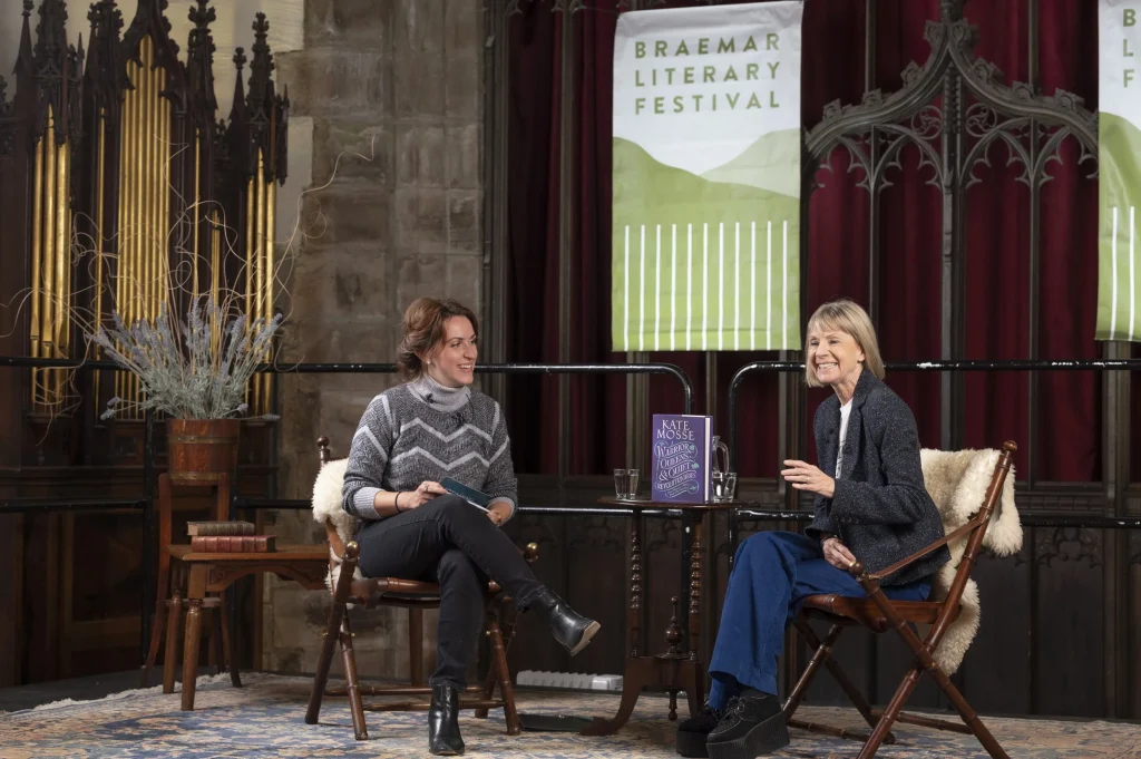 People on stage talking with Braemar Literary Festival banner in the background