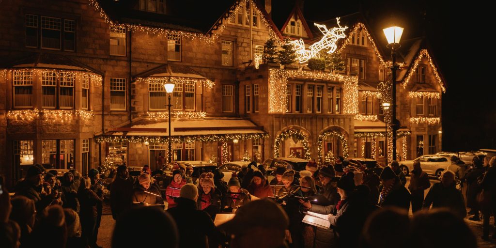 Exterior of hotel with carol singers at Christmas