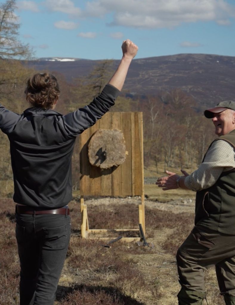 Male guest celebrating his axe throwing with the guide in the Highlands.